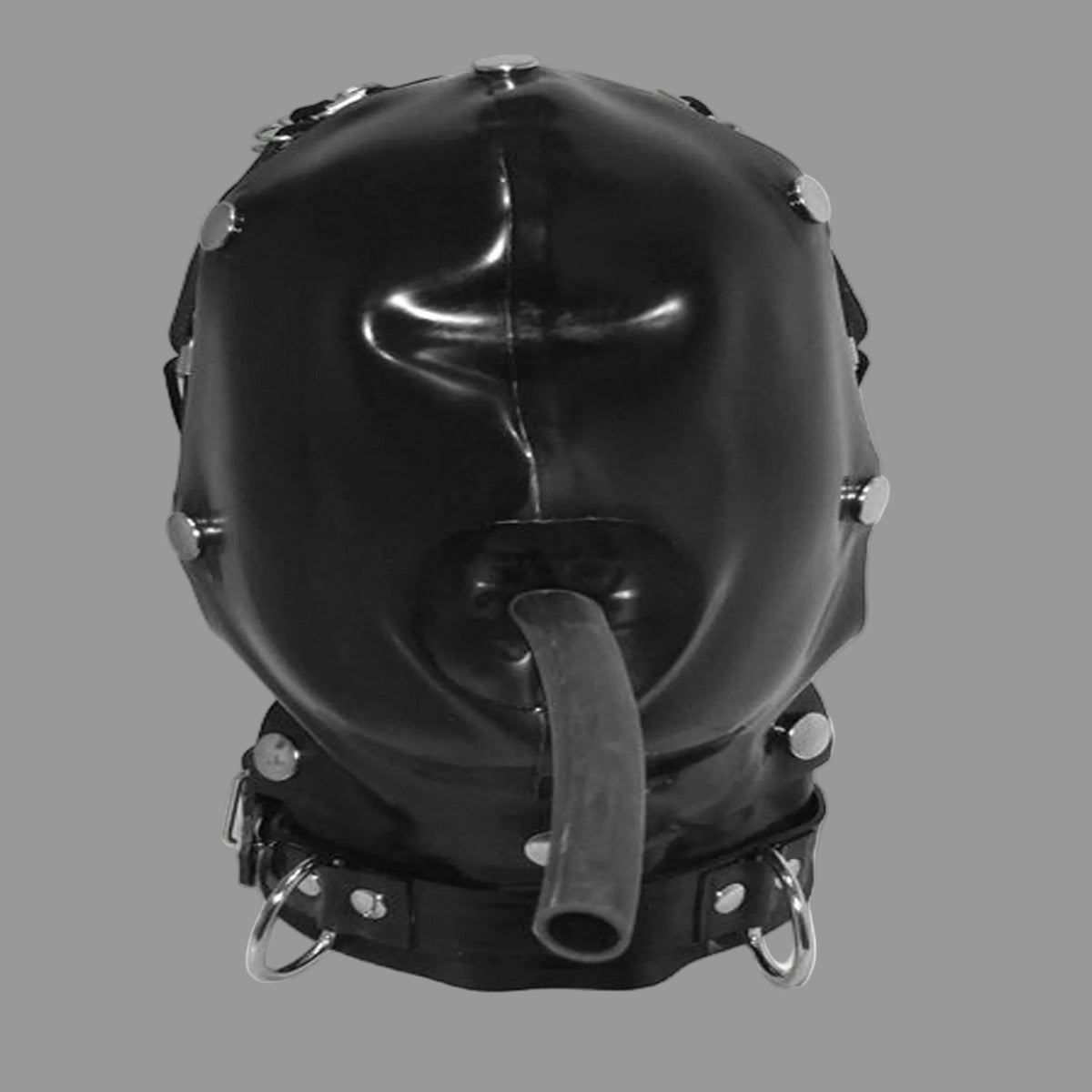 A glossy black latex hooded mask with a protruding gag tube, decorated with silver metal studs and rings, shown against a plain off-white background.